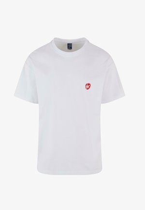 Biely krátky rukáv tričko vyrobené z bavlny, s malým červeným vyšitým srdcom na ľavej hrudi. Klasický okrúhly výstrih.