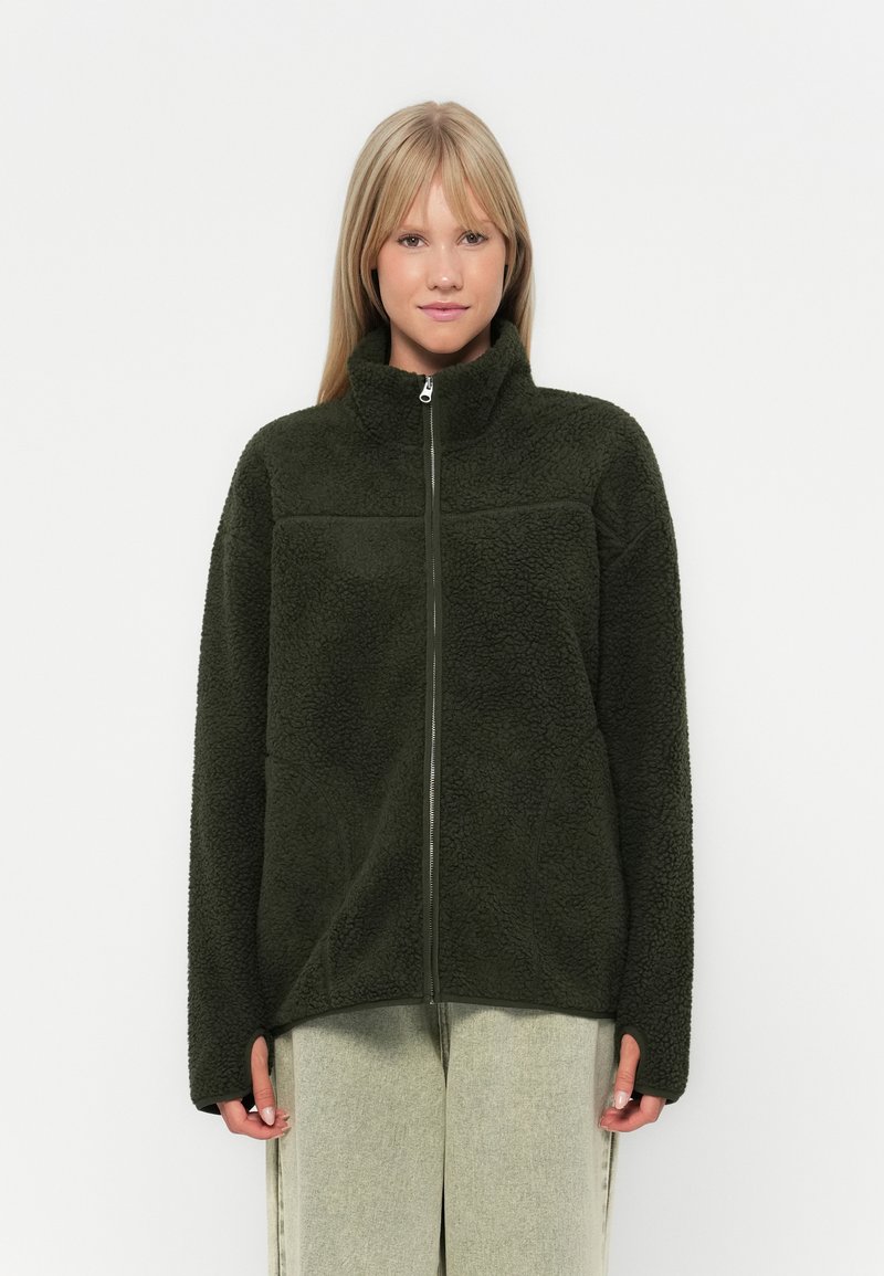 Giacca in fleece verde scuro con colletto alto e zip completa, caratterizzata da una superficie tessurizzata e una vestibilità comoda.