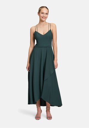 Abito senza maniche di un verde scuro, con scollatura a V, spalline sottili e orlo asimmetrico. Realizzato in un tessuto liscio con un'elegante caduta e movimento.