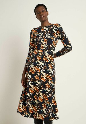Langärmliges, marineblaues Kleid mit einem mehrfarbigen Blumenmuster in Orange, Creme und Blau. A-Linien-Silhouette mit einem Saum, der unter das Knie reicht.