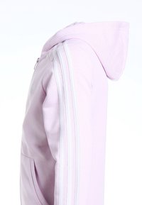 Sweat-shirt à capuche rose avec des rayures blanches le long des manches, doté d'une fermeture zippée, fabriqué à partir d'un tissu doux, conçu pour le confort.