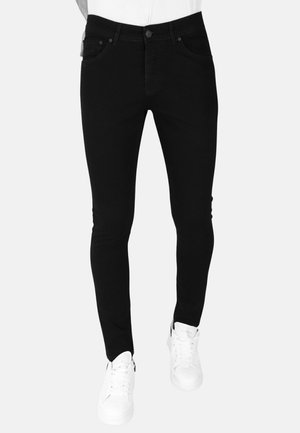 Zwarte denim jeans met een slim fit, voorzien van voorzakken, knoopsluiting en een gladde textuur. Gecombineerd met witte sneakers.