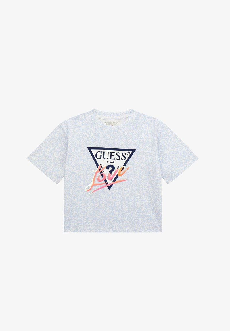 Világoskék, rövid ujjú póló, fehér virágmintával, háromszög alakú logóval, amelyen a "GUESS" és a "Love" színes betűkkel van rajta a mellrészen.