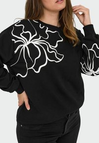 Black sweatshirt featuring bold white floral outline design on one side, long sleeves, and ribbed cuffs. Soft, cotton material.