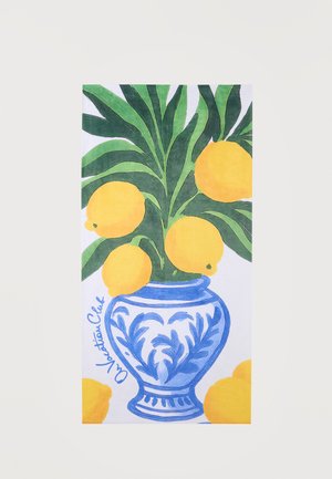 Modro-bela keramična vaza z zelenimi listi in petimi rumenimi limonami, z dodatnimi limonami na dnu, na belem ozadju.