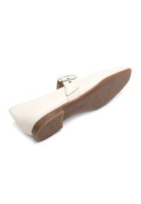 Sandalie din piele albă cu vârf ascuțit, detaliu cu cataramă argintie și talpă din cauciuc texturat de culoare maronie. Design elegant și finisaj neted.