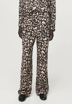 Pantalones negros con un diseño fluido, con un patrón abstracto en beige y crema, hechos de una tela ligera con una textura suave.