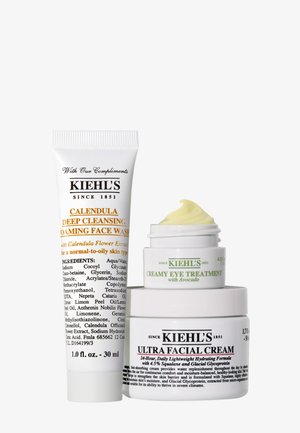 Trois produits de soin Kiehl's : nettoyant visage profond à la calendula, soin yeux crémeux à l'avocat, et crème ultra visage empilés ensemble.