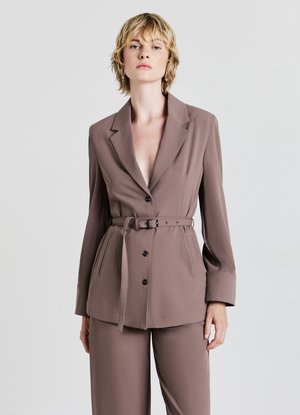 Blazer marrone con cintura, revers a punta e chiusura a bottone. Maniche lunghe e tasche laterali. Vestibilità sartoriale, realizzato in un tessuto leggero.
