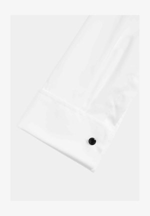 Puño de camisa blanca con una textura suave y brillante, acentuado con un botón negro. El puño está perfectamente elaborado y tiene un diseño nítido.