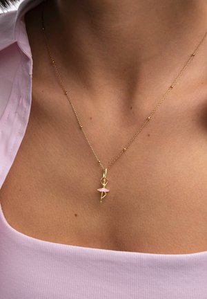 Gouden ketting met een klein ballerina-hangertje met een roze tutu, hangend aan een fijne ketting met kleine kralenaccenten.