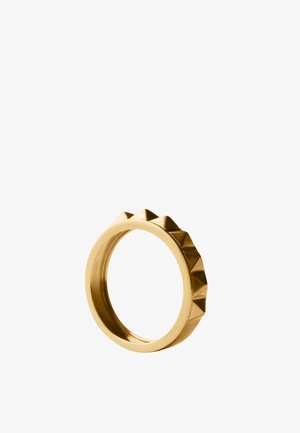 Anillo de metal color oro con una banda interior lisa y una fila de tachuelas en forma de pirámide espaciadas uniformemente en el borde exterior.