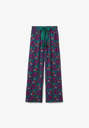 Weite Hosen aus lebhaft grünem Stoff mit einem mehrfarbigen floralen Paisleymuster. Sie verfügen über einen Gummizug mit Quasten.
