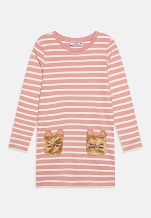 Maglietta a maniche lunghe a righe rosa e crema con due tasche a forma di faccia di orsetto di peluche. Materiale in cotone morbido con scollo rotondo e vestibilità sagomata.