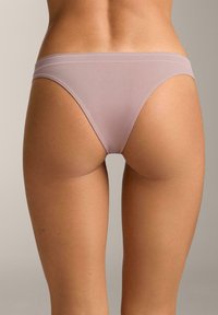 Svjetloljubičasti tange gaćice od mekanog, glatkog tkanja, s minimalističkim dizajnom, bešavnim pojasom i bez vidljivih uzoraka.
