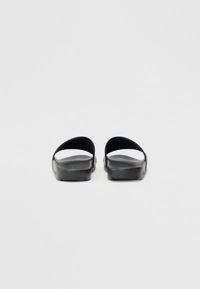 Infradito neri con un design a fascia curva, suola piatta e texture liscia. Stile semplice e minimalista senza motivi o parti metalliche visibili.