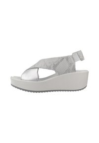 Sandalias de cuña plateadas con diseño de tiras cruzadas, que cuentan con material texturizado y una suela plana blanca con detalles antideslizantes.