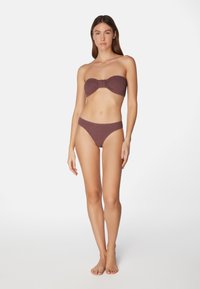Bikini-set i djup mauve som har en bandeau-topp med en rosett-detalj och matchande låg midja bikiniunderdel. Tyget har en räfflad struktur.