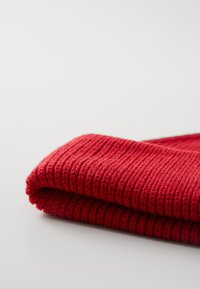 Red knit fabric, folded with ribbed texture. Thick, soft fibers create an even, warm appearance. Neatly rolled edges with no visible patterns.
