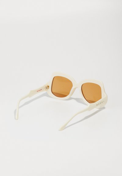 Ochelari de soare oversized albi cu lentile de culoare marron, design cu un cadru unghiular și detalii cu logo pe braț. Material plastic neted.