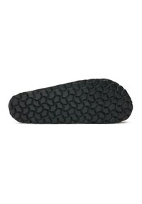 Black rubber shoe sole with a raised, wave-like tread pattern. The shape is elongated, featuring a smooth edge and flexible texture.