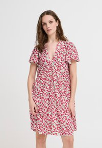 Floral dress in light fabric, featuring a deep V-neck, short ruffled sleeves, and a pink, red, and green floral pattern on a white background.
