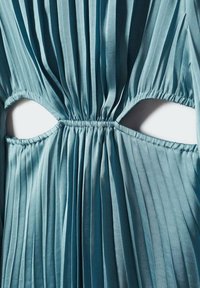 Robe bleu plissée avec des découpes sur les côtés, cintrée à la taille avec un élastique, en tissu léger et fluide.
