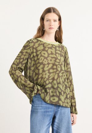 Doorzichtig blouse met lange mouwen en een groen luipaardprint op een bruine achtergrond. Voorzien van een ronde halslijn met een felgele afwerking.