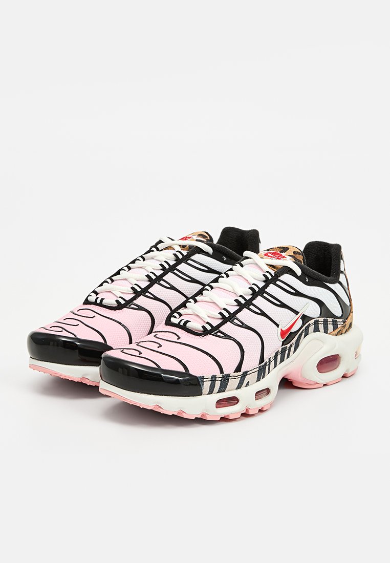 Baskets avec une tige en mesh noir et blanc rayé, accents roses, logo Nike rouge et une semelle blanche épaisse avec un amorti d'air visible.