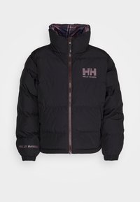 Veste matelassée noire avec col haut, fermeture éclair à l'avant et logo Helly Hansen sur la poitrine et le poignet de la manche gauche.