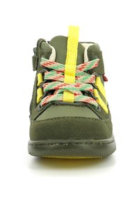 Zapato para niños en gamuza verde y tela con acentos amarillos, cordones de colores con patrón y puntera reforzada, diseñado para durabilidad y comodidad.