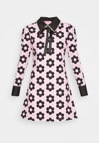 Svart och rosa långärmad klänning med ett hexagonmönster, en svart krage och ett bandknyt vid halsen. Slät tyg med en figursydd silhuett.
