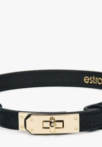 Czarna skórzana bransoletka z metalowym zapięciem w kolorze złotym o prostokątnym kształcie i teksturowanych detalach. Nazwa marki wytłoczona na złoto.