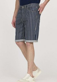 Shorts en denim bleu foncé avec des rayures verticales blanches, dotés d'un ourlet retourné, de cinq poches et d'une fermeture à bouton à l'avant.