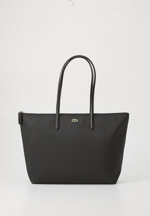 Borsa a tracolla nera con due lunghi manici, una chiusura zip superiormente e un piccolo logo di coccodrillo verde centrato sotto i manici.