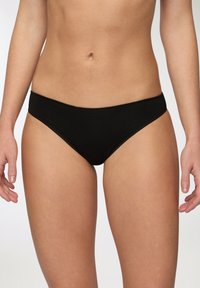 Perizoma nero realizzato in cotone lisci, con vita a media altezza e design a copertura minima. Bordo senza cuciture per un maggiore comfort.