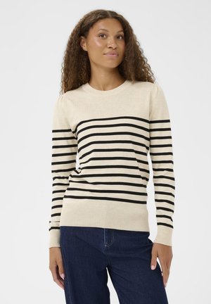 Beiger Pullover mit schwarzen horizontalen Streifen, geripptem Halsausschnitt und Saum, enganliegende lange Ärmel, weiche Textur, getragen mit dunkelblauen Jeans.