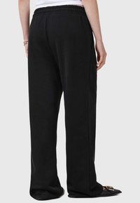 Zwarte sweatpants met een relaxte pasvorm, elastische tailleband en zijzakken. Soepele stof met rechte pijpen en geen zichtbare patronen.