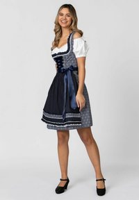 Dunkelblaues Dirndlkleid mit weißer Bluse, floralem Muster, Spitzenakzenten und Satinschleife. Verfügt über kurze Ärmel und einen knielangen Rock.