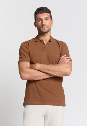 Bruine polo gemaakt van katoen, met een kraag en een knoopsluiting met drie knopen. Korte mouwen met een effen textuur en een subtiele merklogo op de borst.