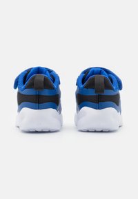 Baskets de sport bleu et noir avec tige en maille, col rembourré, étiquettes au talon et semelle en caoutchouc blanc. Présente un design épuré pour le confort.