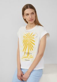 Witte katoenen T-shirt met een gele palmboomafbeelding, de tekst "Summer Club" en opgerolde mouwen. Zachte textuur, relaxte pasvorm.