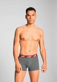 Gray boxer shorts with a red and black elastic waistband featuring the Puma logo, crafted from a soft, stretchy fabric for comfort.