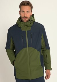Vandtæt jakke med farveblokeret design i navy og olivengrøn, med lynlåslommer og justerbar hætte. Glat tekstur.