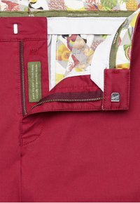 Rode organische katoen shorts met een rits, een decoratieve binnenband met een fruitpatroon, en een klein metalen logo detail.