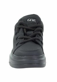 Czarne buty sportowe z teksturowaną gumową podeszwą, okrągłym noskiem i sznurowanym zapięciem. Posiadają logo na języku oraz wzmocnione oczka.