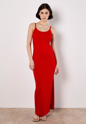 Robe maxi rouge à rayures avec de fines bretelles, dotée d'une fente sur le côté pour faciliter les mouvements. Fabriquée en matière lisse et extensible.