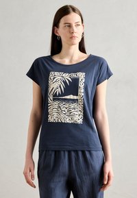 Navy blue cotton t-shirt with short sleeves featuring a white tropical landscape graphic and border design. Relaxed fit.