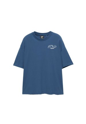 T-shirt bleu à manches courtes avec col rond et texte blanc "STUS Outer Space Customs" sur le haut gauche de la poitrine.