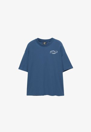 T-shirt bleu à manches courtes avec col rond et texte blanc "STUS Outer Space Customs" sur le haut gauche de la poitrine.